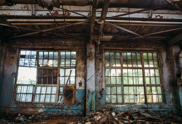 Großes zerbrochenes Fenster in verlassenem Industrielager oder Fabrikgebäude im Inneren, Ruinen und Abrisskonzept — Stockfoto