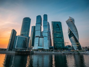Moscow City - fütüristik mimarisi gökdelenler binaları ile yeni modern uluslararası iş merkezi Panoraması Moskova Nehri günbatımında yansıtıyordu.