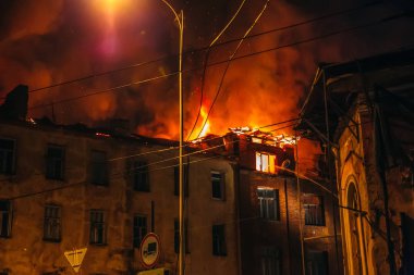 Yanan eve gece, ateş ve duman ve alevler içinde binanın çatı