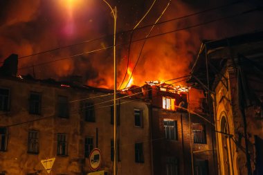 Yanan eve gece, ateş ve duman ve alevler içinde binanın çatı