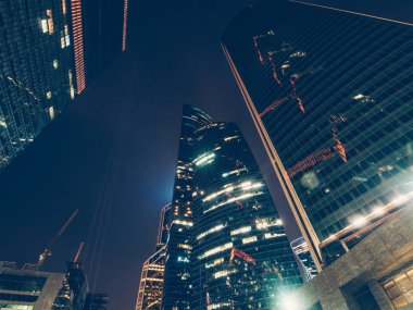 Gece ışıklı pencereler ve ışık ile Moskova şehir merkezinde iş binalarda modern futuristik gökdelen