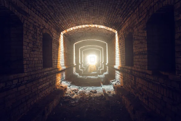 Light in the end of tunnel. Way to freedom concept. Underground industrial long brick corridor — Stock Photo, Image