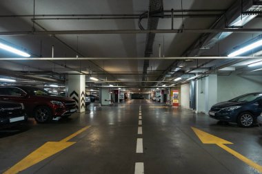 Birçok araç ve okları katta modern alışveriş merkezi altında iç aydınlatmalı Yeraltı otopark