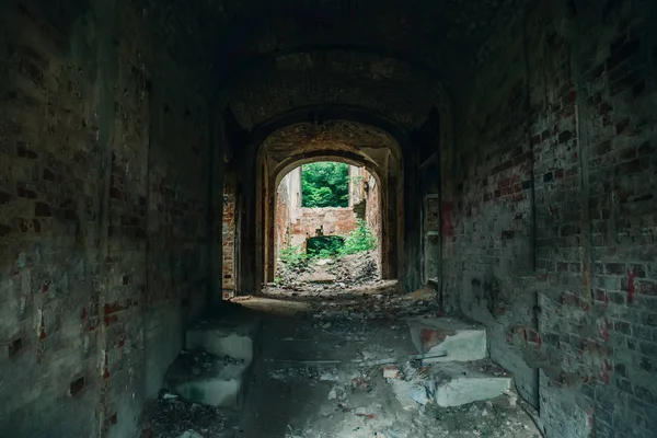 En el interior arruinado, abandonado antiguo edificio de ladrillo envejecido castillo cubierto de hierba y plantas — Foto de Stock