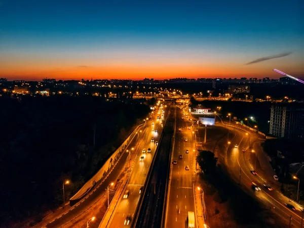 Vista aérea de la ciudad nocturna con carreteras iluminadas y tráfico de automóviles — Foto de Stock