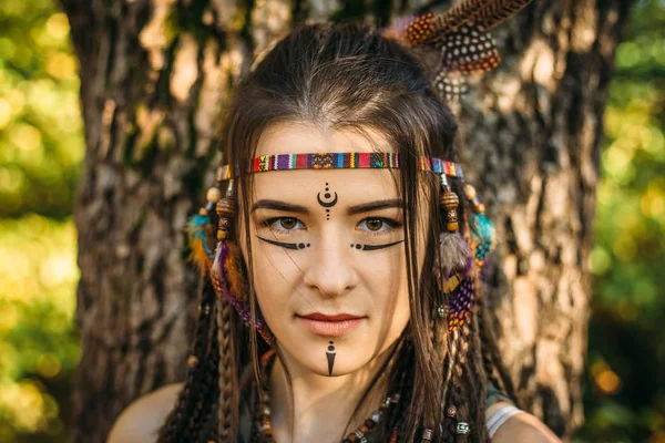 Porträt eines jungen Mädchens im Bild der amerikanischen Ureinwohner, Nahaufnahme, junge attraktive Kriegerin blickt in die Kamera — Stockfoto