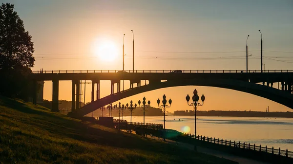 Panorama z zachód słońca nad rzeką, nowoczesny most i miasto nabrzeże, piękny wieczór miejski krajobraz — Zdjęcie stockowe