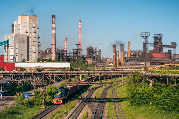 Industrial background, panorama of metallurgical processing refinery plant with towers and chimneys and railroad with wagons