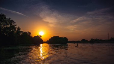 Gölgeler ve bulutlar gökyüzü üzerinde ağaçlarının silüetler ile Nehri üzerinde güzel dramatik gün batımı