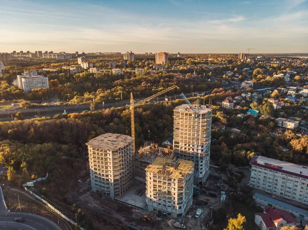 Luchtfoto above, bouw van moderne huizen of gebouwen met kranen en andere industriële voertuigen bij stad achtergrond — Stockfoto