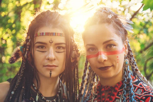 Две молодые симпатичные девушки в образе коренных американцев смотрят в камеру — стоковое фото