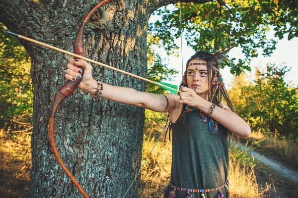 Ung vacker flicka i bilden av Native American med pil och båge i händer redo att skott, kvinnlig krigare porträtt — Stockfoto