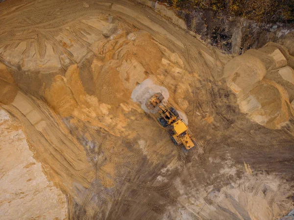 Gelber Bagger oder Planierraupe arbeitet auf Baustelle mit Sand, Luftaufnahme oder Draufsicht — Stockfoto