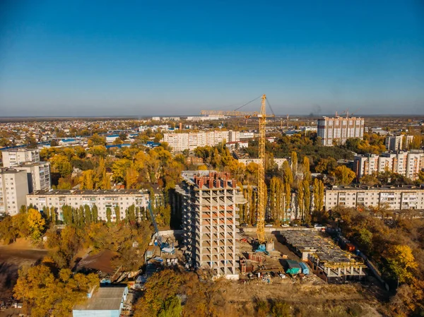 Luchtfoto above, bouw van moderne huis of gebouw met kraan en andere industriële voertuigen onder stad landschap — Stockfoto