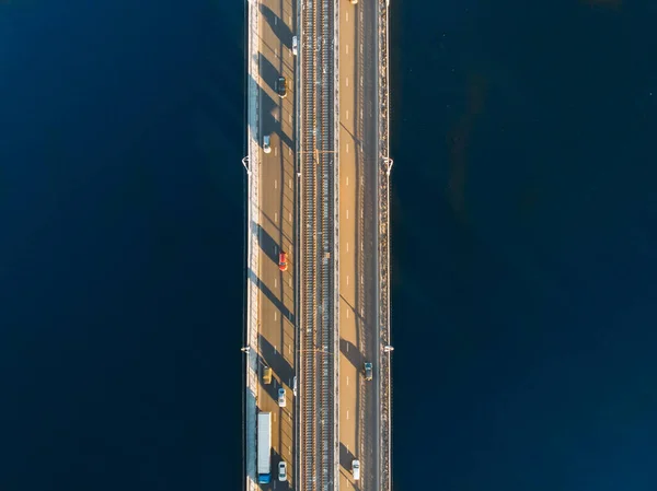 Luft- eller topudsigt fra drone af betonbro med asfaltvej eller motorvej over stor flod med bybiltrafik, bytransport - Stock-foto