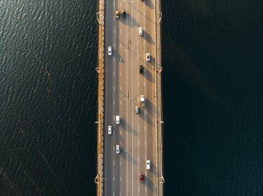 Drone ile asfalt yolda veya otobanda şehir araba trafik, kentsel ulaşım ile büyük nehir üzerinde beton köprü hava veya üst görünümden