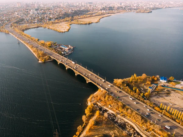 Vista panorâmica aérea do rio grande e ponte de transporte sobre ele com carros no outono cidade europeia — Fotografia de Stock