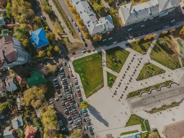 Vue de dessus du drone au-dessus du parc avec pelouses vertes et parking avec des voitures dans le centre de la ville moderne, prise de vue aérienne — Photo