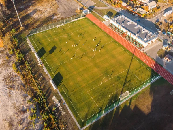 Letecký pohled na malý fotbal nebo fotbalové stadionu s zelený trávník v městské krajině — Stock fotografie