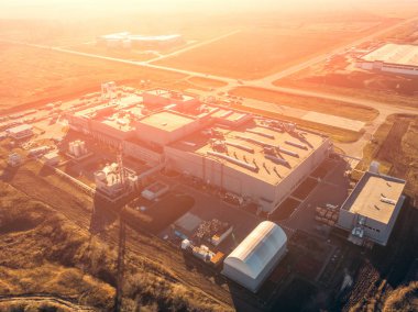 Depo depolama veya endüstriyel fabrika veya Lojistik Merkezi yukarıdan hava dron görünümünü. Sanayi Binaları ve ekipman makineleri günbatımı ışık