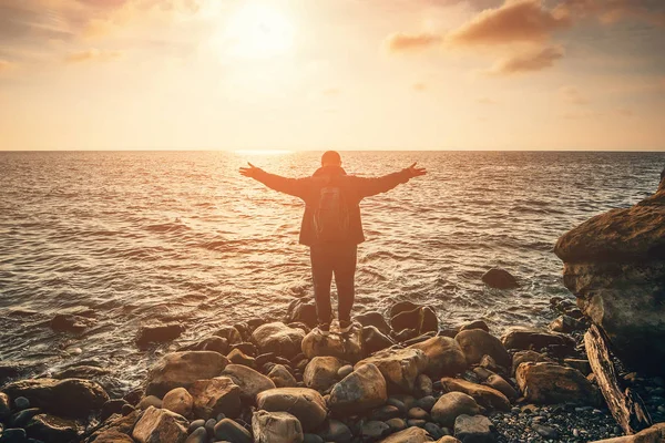 Açık olan adam silüeti silah veya günbatımı ışınları kumsalda deniz üzerinde ayakta eller. Özgürlük ve doğa manzara kavramında rahatla — Stok fotoğraf