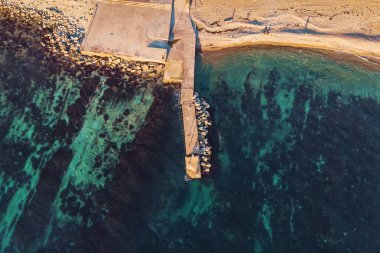 Beton pier yakınındaki plaj ve turkuaz deniz su, hava veya üstten görünüm 