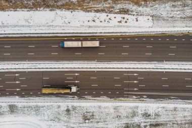 Drone üst görünümden hızlı sürüş araba kamyon trafiği olan kırsal kış asfalt karayolu ya da otoyol yol için
