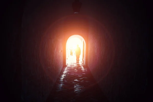 Luz al final del túnel con siluetas de personas, camino a la esperanza y la libertad —  Fotos de Stock