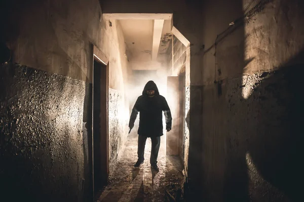 Silhouette of man maniac or killer or horror murderer with knife in hand in dark creepy and spooky corridor. Criminal robber or rapist concept in thriller atmosphere — Stock Photo, Image