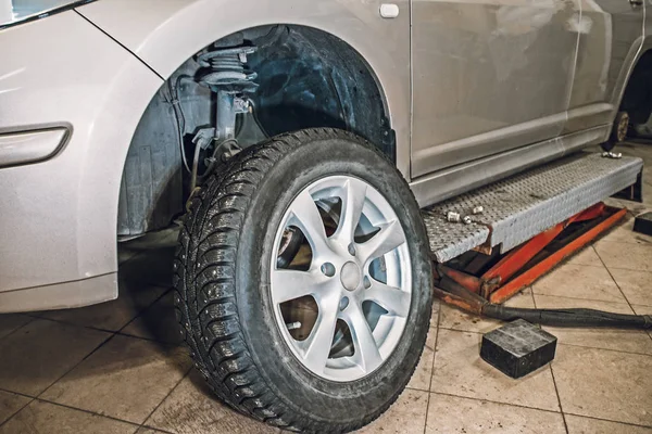 Coche en garaje de taller de servicio de reparación de automóviles con equipo de reparación especial para ruedas de neumáticos de repuesto —  Fotos de Stock