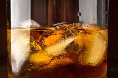 Buz küpleri ile bardakta viski kapatmak yukarıya makro fotoğraf