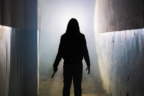 Silhouette de criminel ou maniaque avec couteau à la main dans un vieux bâtiment effrayant, tueur en série avec arme froide — Photo