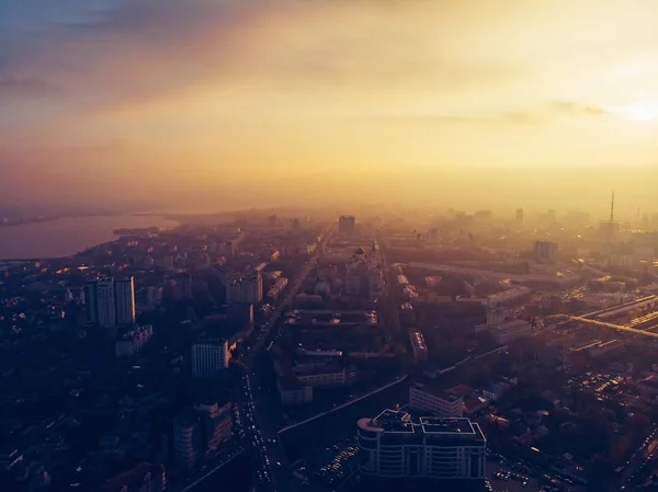 Luchtfoto panorama van dramatische zonsondergang over grote stad in de avond schemering-mist of nevel, drone weergave stadsgezicht — Stockfoto