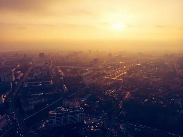 Luchtfoto panorama van dramatische zonsondergang over grote stad in de avond schemering-mist of nevel, drone weergave stadsgezicht — Stockfoto