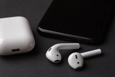 Beyaz Kablosuz bluetooth kulaklık ya da kulaklık, plastik kasa veya kutusu muhafazası ve şarj ve siyah arka plan üzerine smartphone için