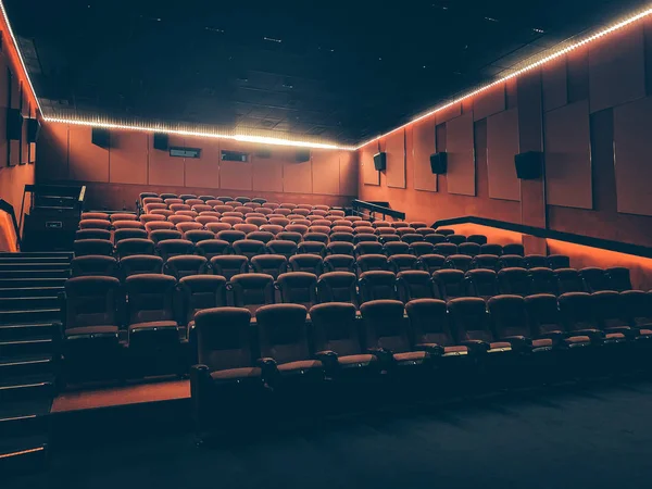 Cine con muchos asientos rojos o sillas en el auditorio vacío oscuro — Foto de Stock