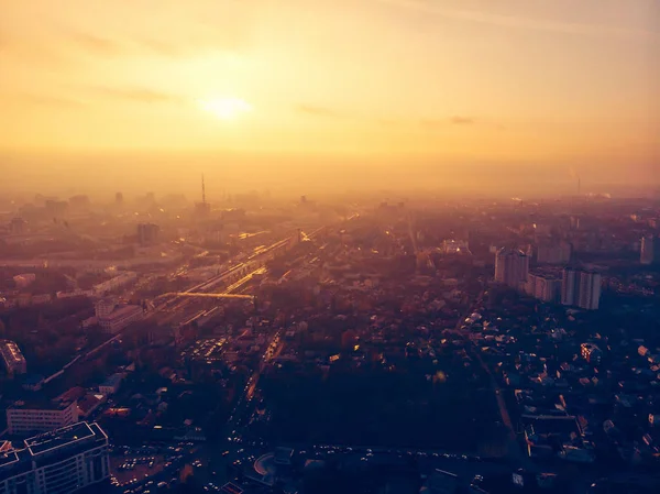 Dramatic sunset over evening city panorama, aerial view from drone, beautiful cityscape