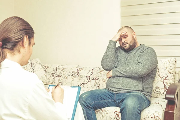 Psychologist listening sad fat man patient and writing notes, mental health and counseling. Psychologist consulting and psychological therapy session concept