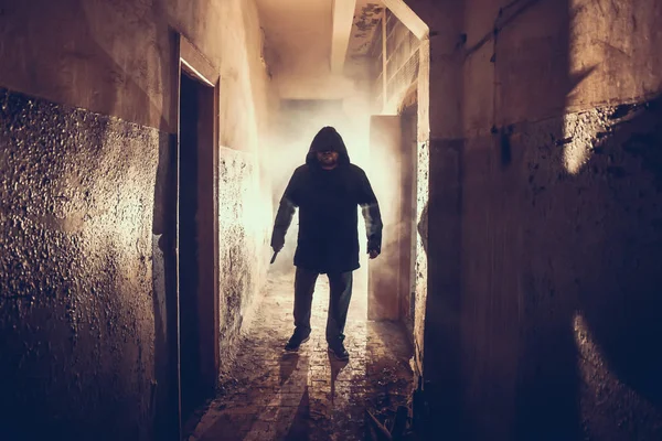 Тёмный силуэт странного опасного человека с ножом в руке в страшном гранж-коридоре или тоннеле — стоковое фото