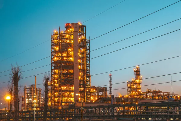 Fábrica ou fábrica de refinaria petroquímica de petróleo industrial com tubos e torres de petróleo com iluminação noturna — Fotografia de Stock