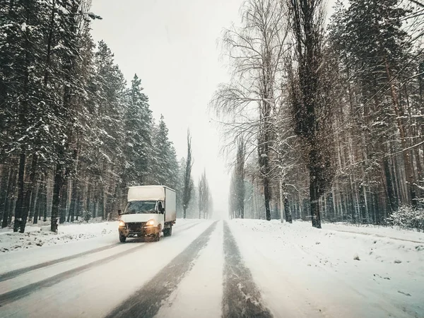 Small truck cargo logistic car on winter country road in winter snowy weather