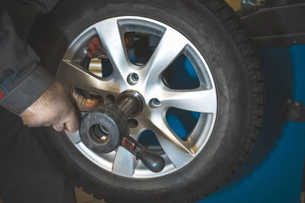 Reparador substitui e equilibrando roda de pneu de carro na ferramenta de equipamento de balanceamento especial no serviço de reparação de automóveis — Fotografia de Stock