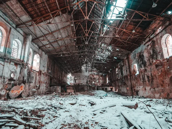 Ruined factory or abandoned warehouse hall with broken roof and snow on floor, nuclear winter concept — Stock Photo, Image