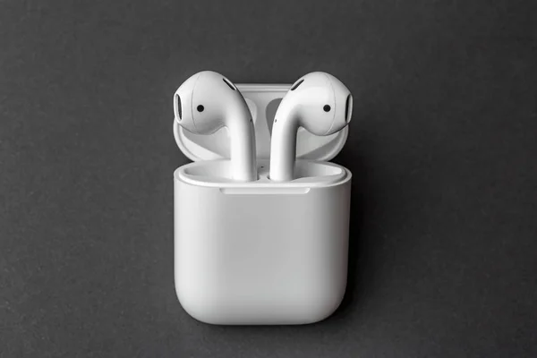 Beyaz Kablosuz bluetooth kulaklık ya da kulaklık ve depolama ve koyu gri arka plan üzerinde şarj için beyaz kutu