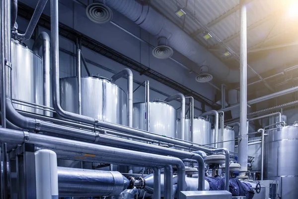 Grandes depósitos de acero para la producción de cerveza alcohólica en la fábrica de cerveza moderna, azul tonificado como fondo industrial abstracto con tubería —  Fotos de Stock