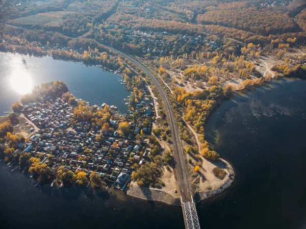 Vista aérea do drone ao litoral com casas e ponte ferroviária sobre a água — Fotografia de Stock