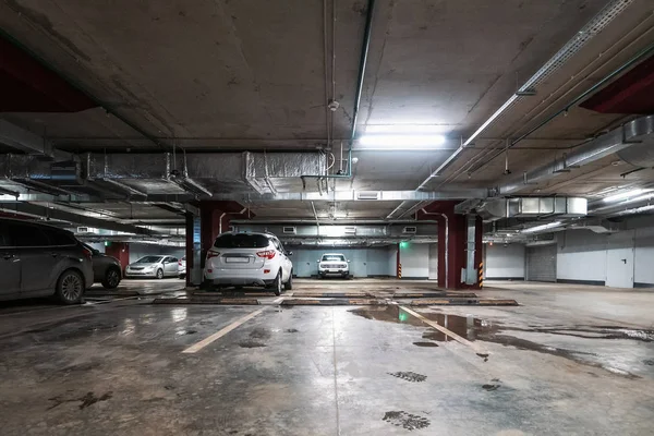 Verlichte ondergrondse auto parkeren garage interieur onder moderne winkelcentrum met veel voertuigen — Stockfoto