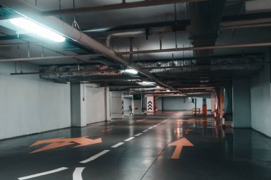 Otomatik araçlar ve okları katta modern alışveriş merkezi altında ışıklı Yeraltı otopark