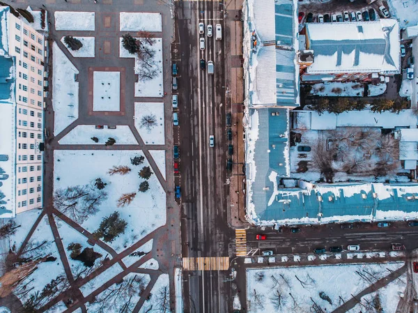 Vue aérienne du drone de la ville d'hiver avec neige, routes, circulation automobile et bâtiments vue du haut vers le bas — Photo