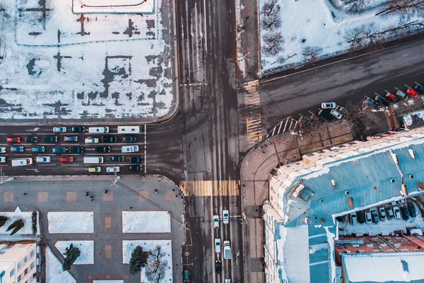 Vue aérienne du drone de la ville d'hiver avec neige, routes, circulation automobile et bâtiments vue du haut vers le bas — Photo